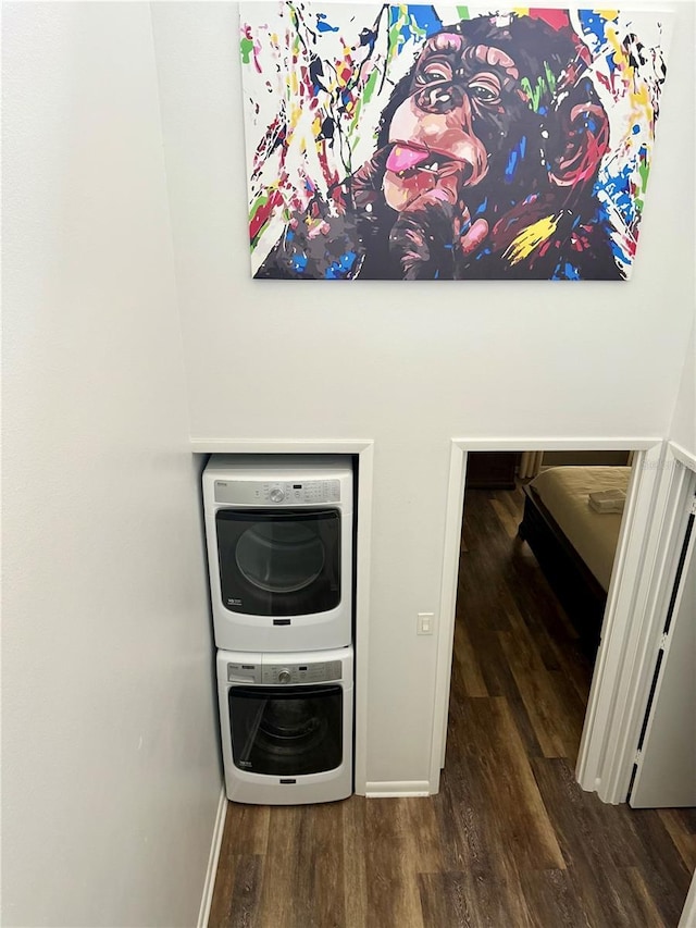 details with stacked washer and dryer, baseboards, and wood finished floors