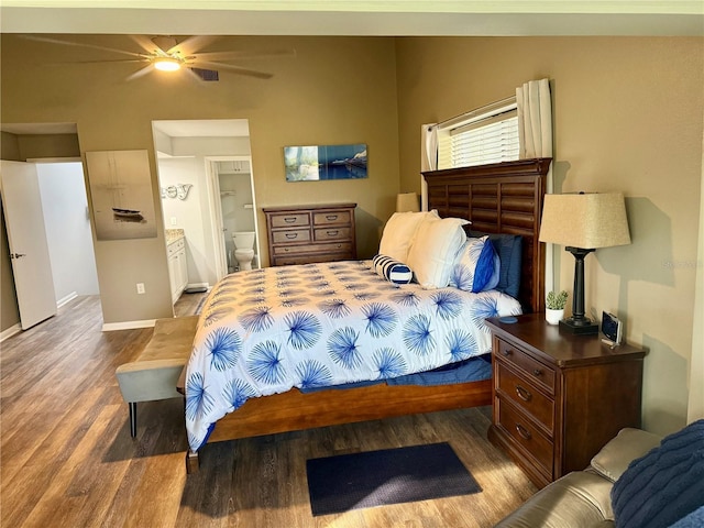 bedroom featuring connected bathroom, baseboards, and wood finished floors