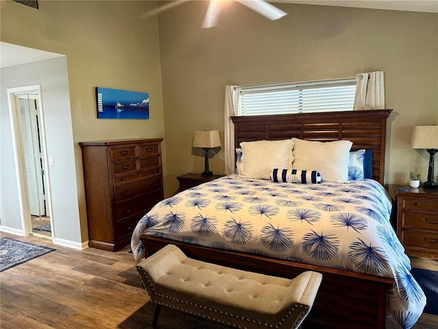 bedroom with visible vents, baseboards, lofted ceiling, ceiling fan, and wood finished floors