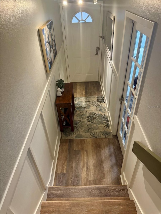 doorway to outside featuring a textured wall and wood finished floors