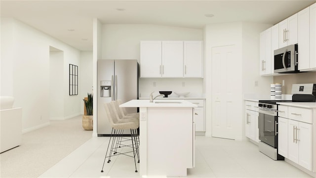 kitchen featuring stainless steel appliances, light countertops, white cabinets, a kitchen island with sink, and a kitchen bar