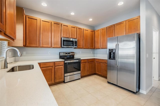 kitchen featuring stainless steel appliances, recessed lighting, a sink, and brown cabinets