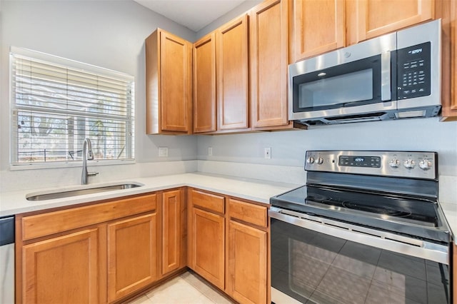 kitchen featuring appliances with stainless steel finishes, light countertops, and a sink