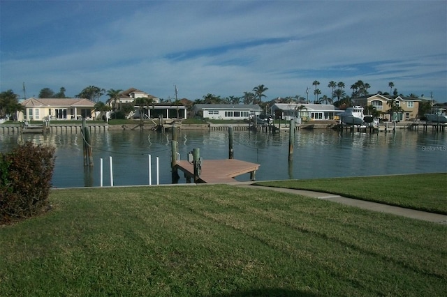 view of dock with a residential view, a water view, and a lawn