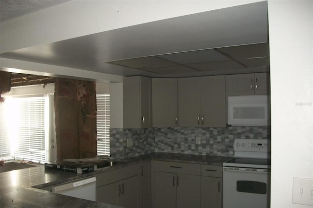 kitchen with dark countertops, white appliances, and decorative backsplash