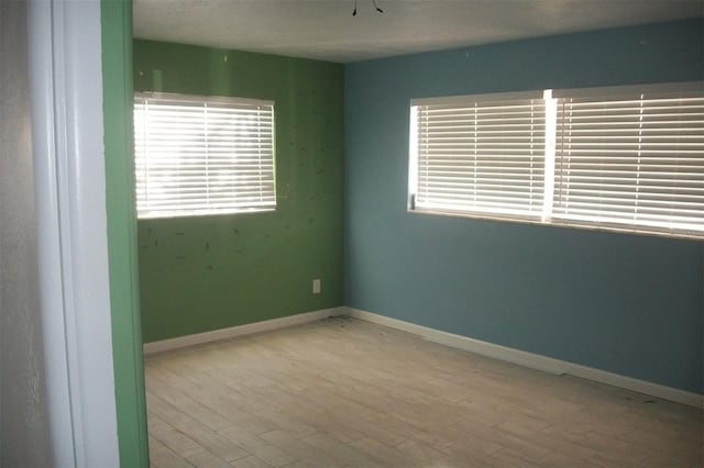 empty room featuring baseboards and wood finished floors