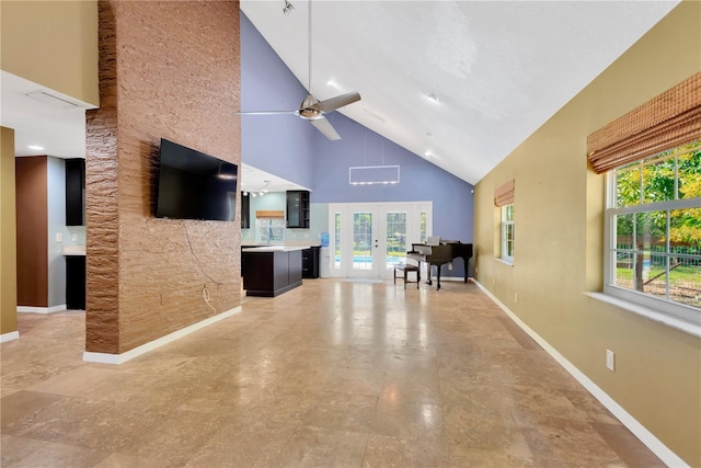 unfurnished living room featuring baseboards, french doors, high vaulted ceiling, and ceiling fan