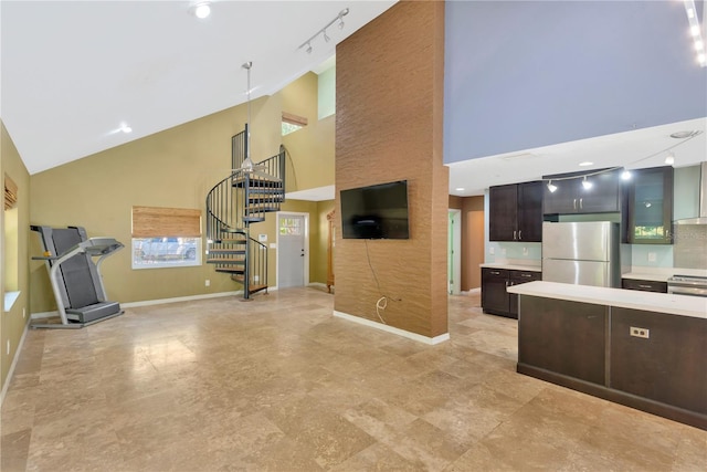 kitchen featuring baseboards, dark brown cabinetry, stainless steel electric stove, light countertops, and freestanding refrigerator