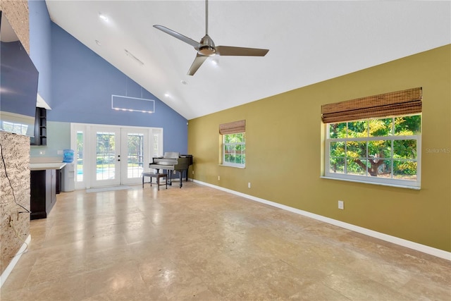 interior space with a ceiling fan, french doors, baseboards, and high vaulted ceiling