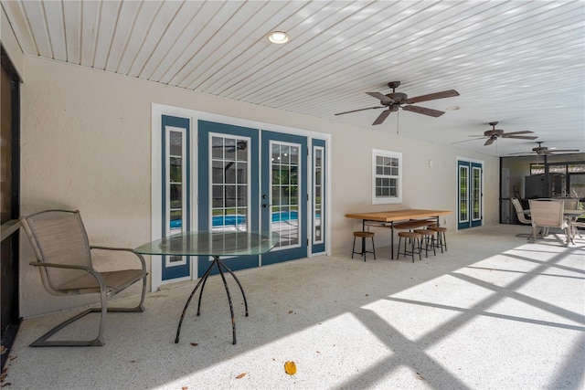 view of patio with french doors, ceiling fan, outdoor dry bar, and outdoor dining space