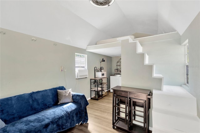 living area with baseboards, washer / clothes dryer, lofted ceiling, and wood finished floors