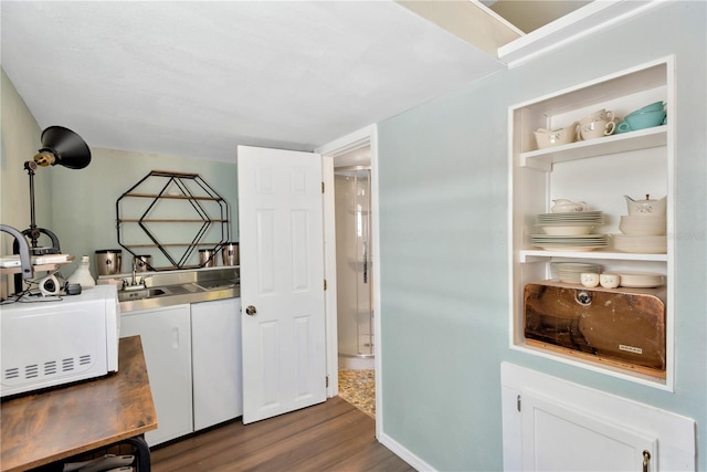 interior space with dark wood finished floors, white microwave, and a sink