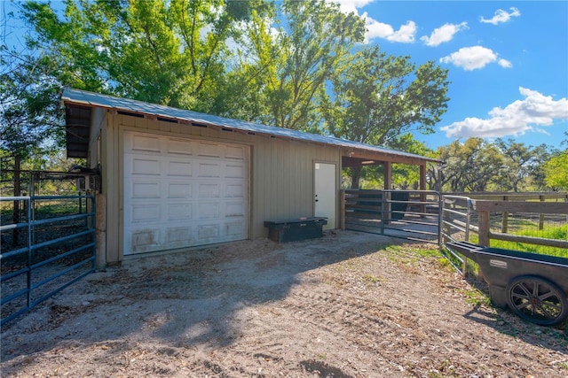 detached garage featuring dirt driveway