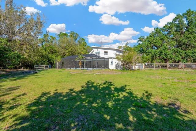 view of yard with a lanai and fence