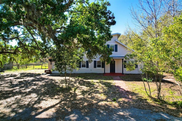 obstructed view of property featuring stucco siding and fence