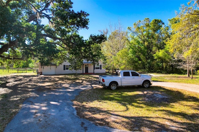 view of front facade featuring fence and driveway