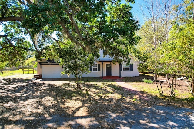 view of front of home featuring stucco siding, driveway, an attached garage, and fence