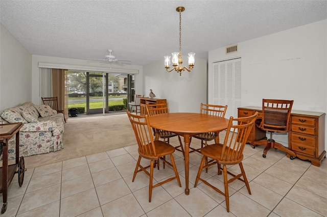 dining space featuring light tile patterned floors, visible vents, light carpet, a textured ceiling, and ceiling fan with notable chandelier