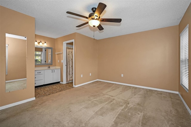 unfurnished bedroom featuring carpet floors, a ceiling fan, baseboards, and a textured ceiling