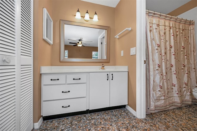 full bathroom featuring ceiling fan, a shower with shower curtain, vanity, baseboards, and a closet