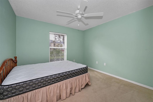 bedroom featuring a textured ceiling, carpet flooring, and baseboards