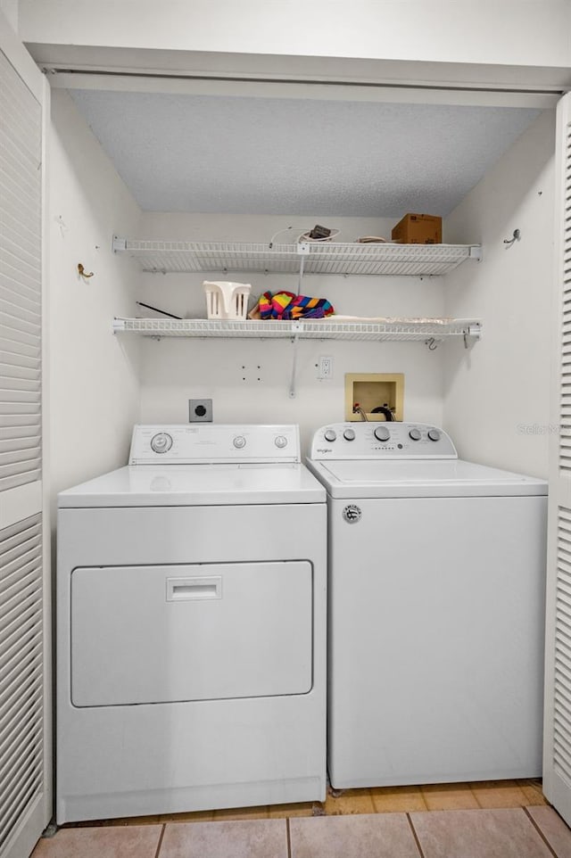 washroom with washing machine and dryer, laundry area, and light tile patterned flooring