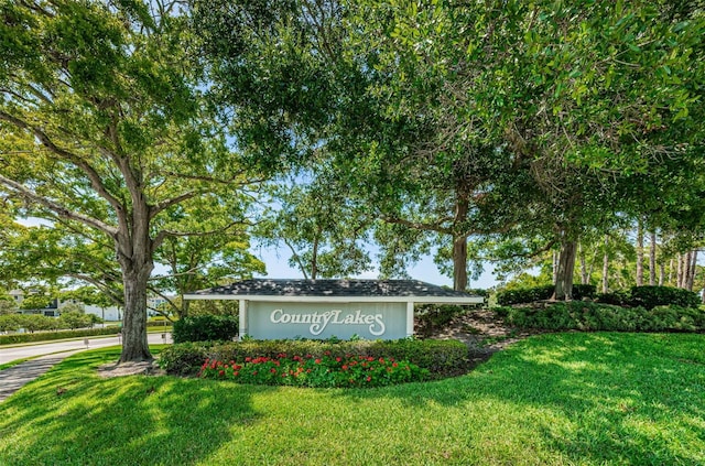 community / neighborhood sign featuring a yard