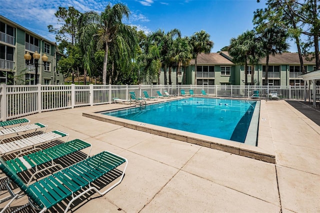 pool with a patio area and fence