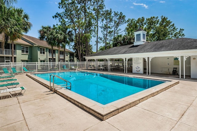 community pool featuring a patio area and fence