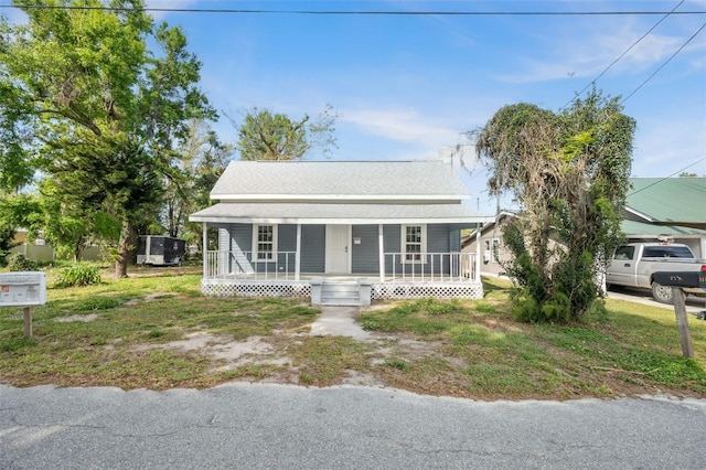 bungalow-style home with covered porch and roof with shingles