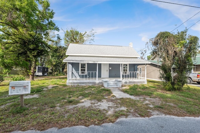 bungalow-style home with covered porch and roof with shingles