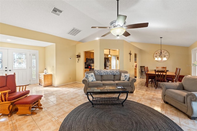 living area featuring light tile patterned floors, baseboards, visible vents, and a textured ceiling