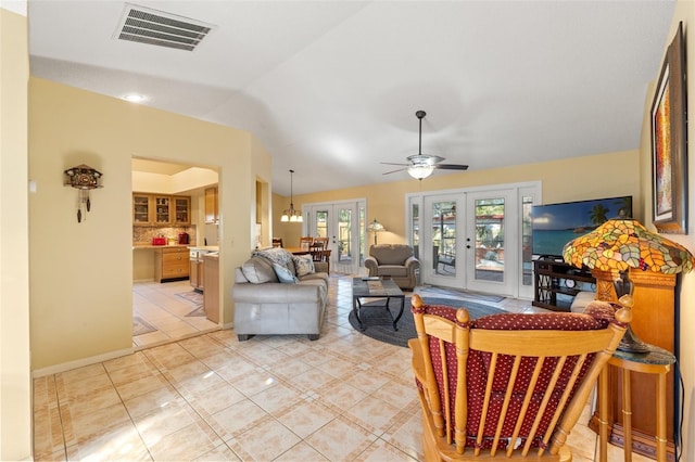 living room featuring french doors, visible vents, a ceiling fan, light tile patterned flooring, and vaulted ceiling