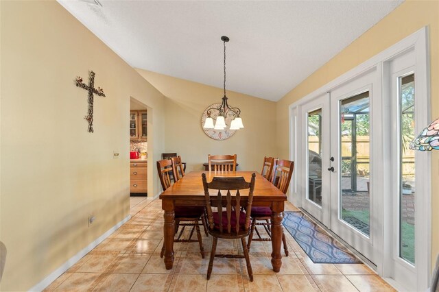 dining space featuring light tile patterned floors, baseboards, lofted ceiling, an inviting chandelier, and french doors