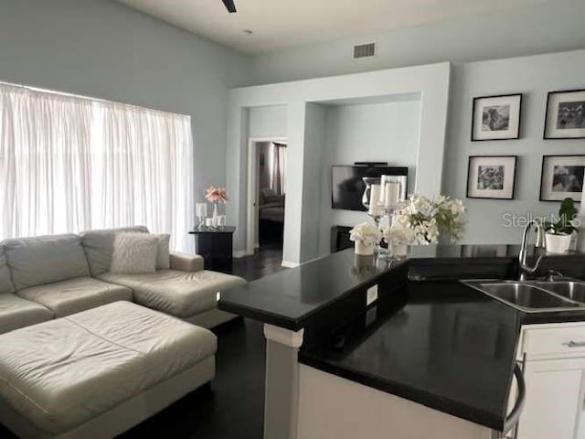 living room featuring visible vents and a ceiling fan