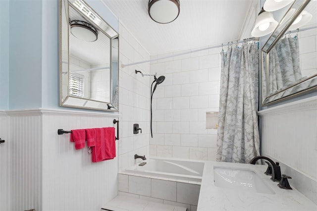 full bathroom featuring tiled shower / bath combo, wainscoting, and vanity