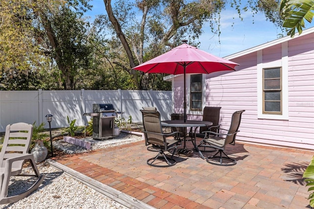 view of patio with fence, area for grilling, and outdoor dining space