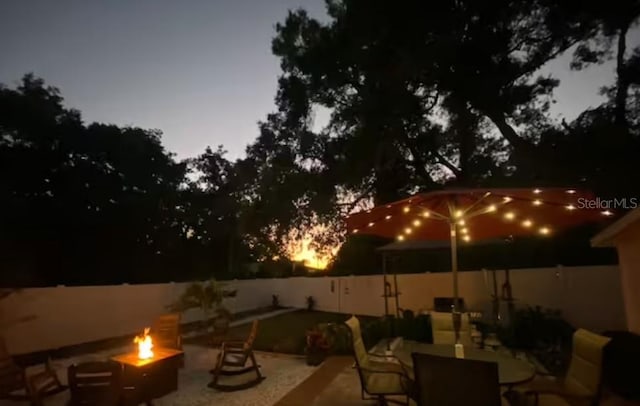 view of patio with fence and a fire pit