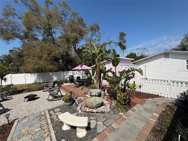 view of patio / terrace with a fenced backyard and a fire pit