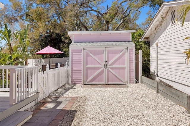 view of shed featuring fence