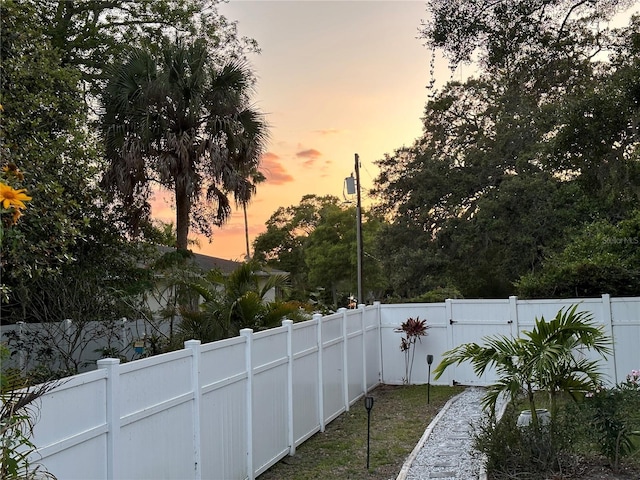 yard at dusk with a fenced backyard