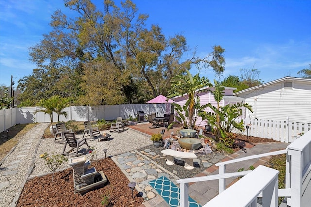 view of yard featuring a patio, an outdoor fire pit, and a fenced backyard