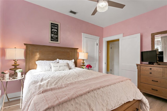 bedroom featuring visible vents, ceiling fan, and light wood-style flooring