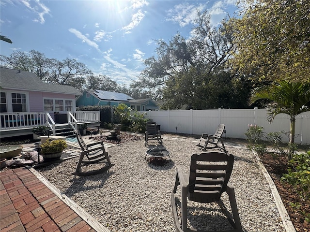 view of yard with a patio area, a fenced backyard, a fire pit, and a wooden deck