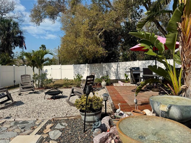 view of patio / terrace with an outdoor fire pit, a fenced backyard, and area for grilling