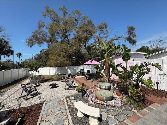 view of patio / terrace with a fenced backyard and a fire pit