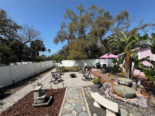 view of patio with a fenced backyard and a fire pit