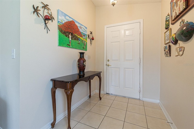 doorway featuring light tile patterned floors and baseboards