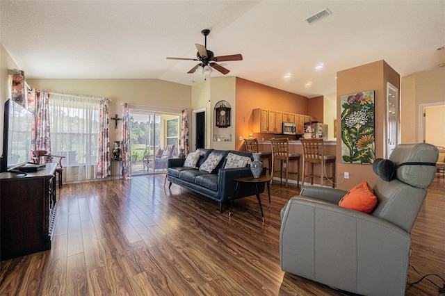 living area featuring dark wood finished floors, lofted ceiling, visible vents, ceiling fan, and a textured ceiling