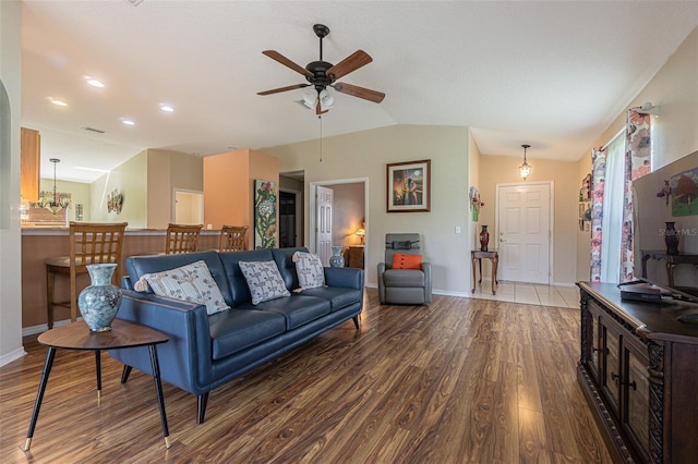 living room featuring lofted ceiling, a ceiling fan, baseboards, and wood finished floors